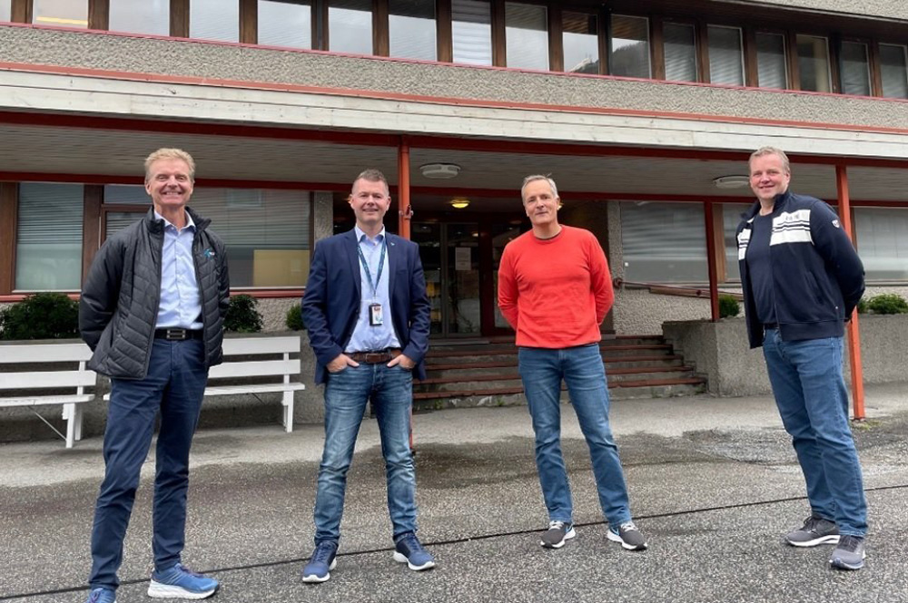 Tre menn står oppstilt framføre rådhuset i Svelgen. Foto.